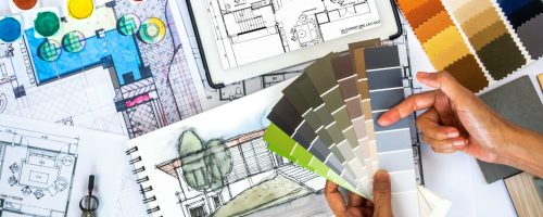 Top view of architect & interior designer working at worktable with  color swatch, tablet, sketch & blue print/ Real estate business & renovation conceptual